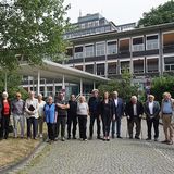 Personengruppe vor dem Gebäude stehend