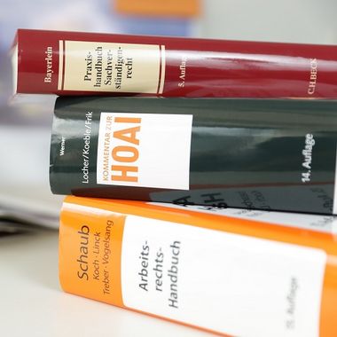 Nachschlagewerke Rechtsabteilung, 3 Bände liegen auf dem Tisch