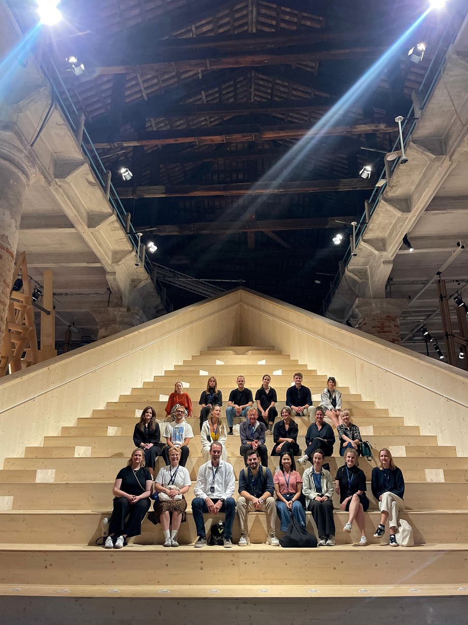 Eine Gruppe von Männern und Frauen sitzt auf einer großen Treppe in mehrere Reihen verteilt.