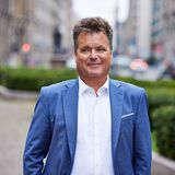 Farbporträt von Jürgen Dusel vor urbanem Hintergrund