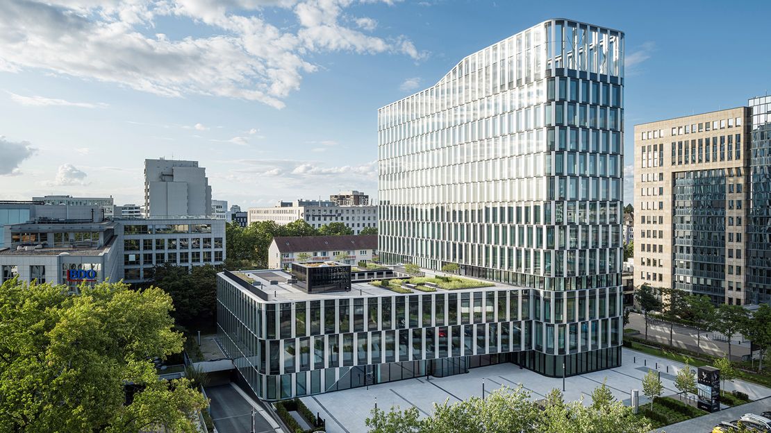 TdA: LYGHT, Düsseldorf Außenansicht aus der erhöhter Perspektive eines Bürogebäudes: ein zwölfgeschossiges Bürohochhauses mit erweitertem Sockelbaum flachen und eine