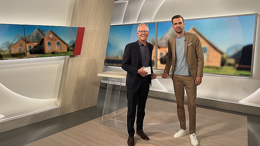TdA 2024: WDR-Interview Zwei Männer an einem Moderationstisch im Studio stehend