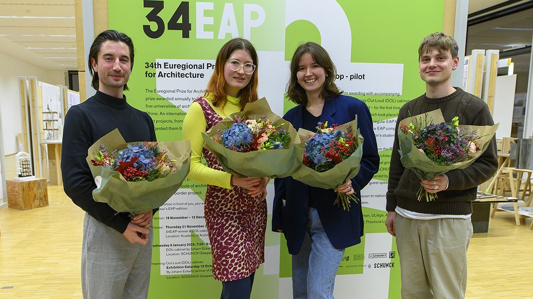EAP: Preisträger*innen Vierergruppe mit den beiden jungen Frauen in der Mitte vor dem Plakat zum EAP