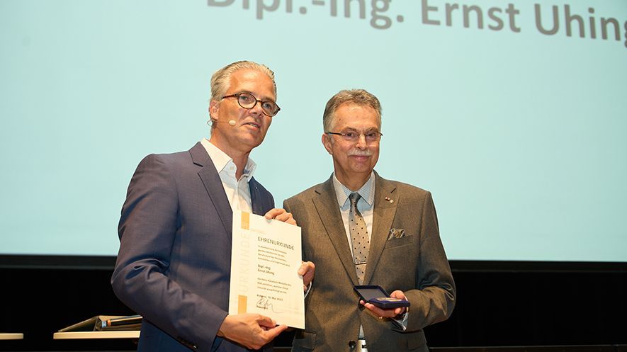 Kieselack-Medaille für Uhing Zwei Männer auf der Bühne, einer hält eine Urkunde in der Hand