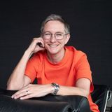 Halbkörper-Portrait, sitzend vor schwarzem Hintergrund