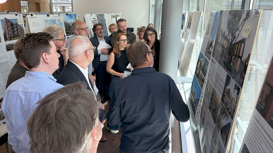 Eine Gruppe Menschen im Gespräch vor Schautafeln mit Fotos