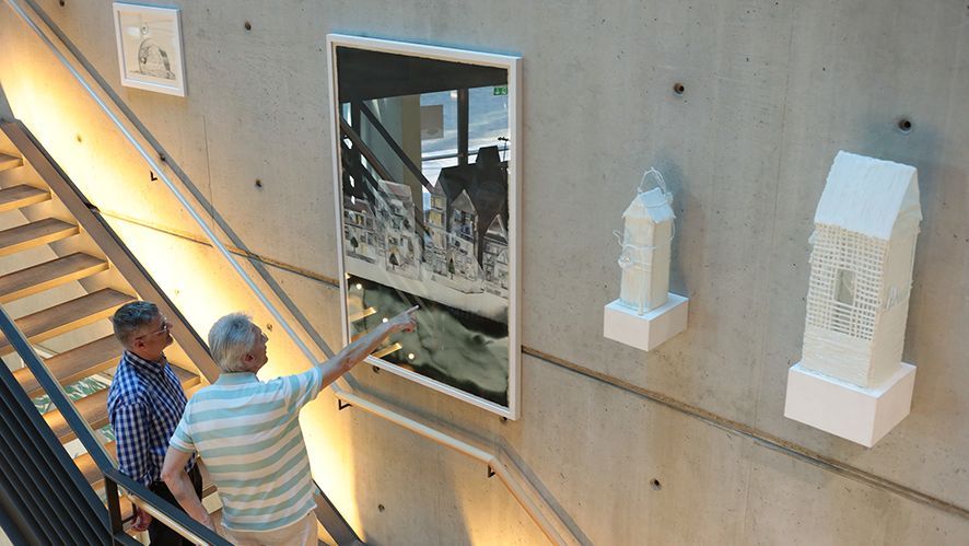 großformatiges Aquarell und weiße Skulpturen aus Gips an der Betonwand mit Betrachter*innen davor