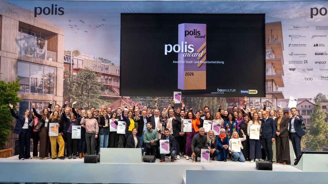 Gruppenbild mit vielen glücklich aussehenden Menschen auf der Bühne