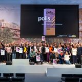 Gruppenbild mit vielen glücklich aussehenden Menschen auf der Bühne