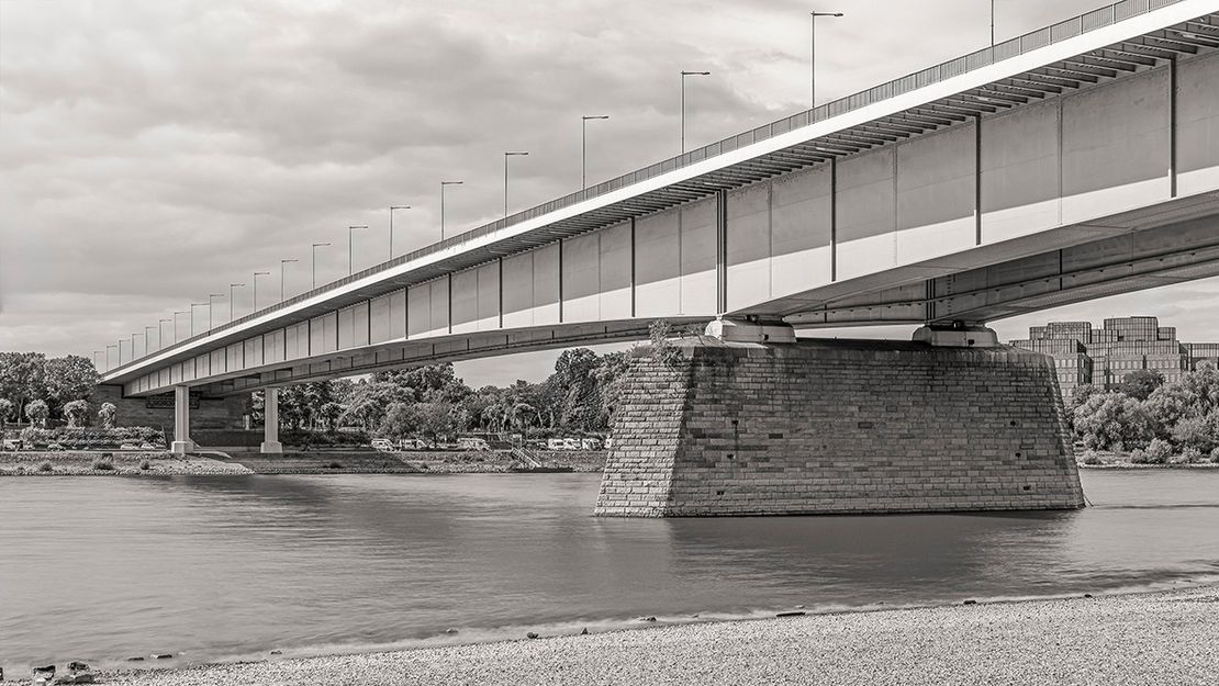 Eine Brücke über Gewässer, das Foto ist in schwarz-weiß.