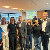 Gruppenbild mit fünf jungen Frau und zwei Herren stehend in einem Tagungsraum