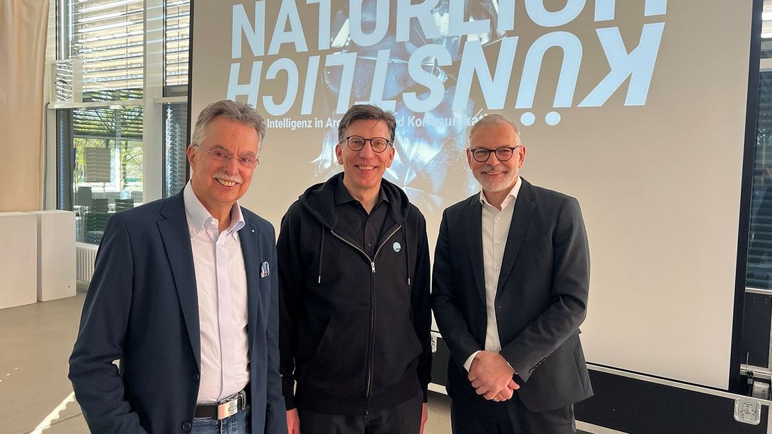 AMM-Symposium Gruppe 1 Drei Männer vor Leinwand mit Grafik
