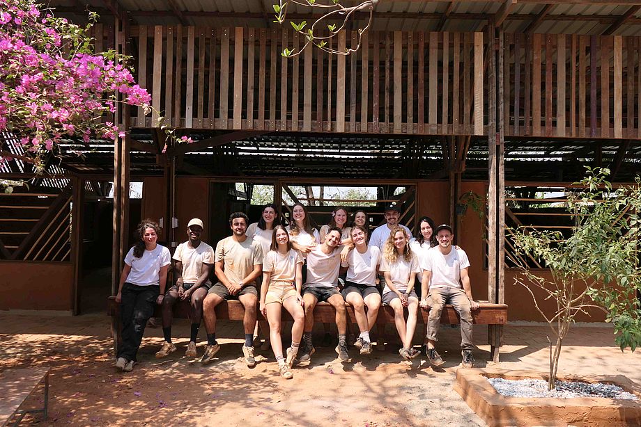 Stiftung Deutscher Architekten: Hands-on 2025: Auf dem Bild sind Teilnehmerinnen und Teilnehmer des Projekts "Hands-on". Sie sitzen und stehen vor einem Schulgebäude in Thailand.