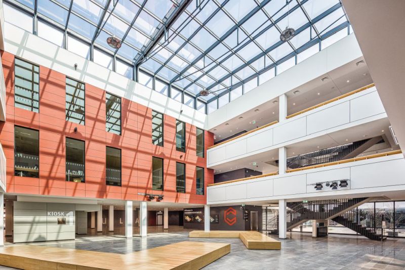 Innenaufnahme des Berufskollegs: Modernes Schulgebäude mit offenem Foyer, Laubengängen und Glasdach